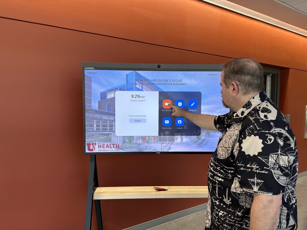Photo of a person using the DTEN "New Meeting" button